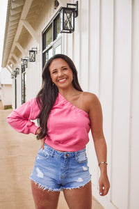 We are loving this super pretty one shoulder sweatshirt top in pink! Has a cropped fit and a one shoulder sleeve. 