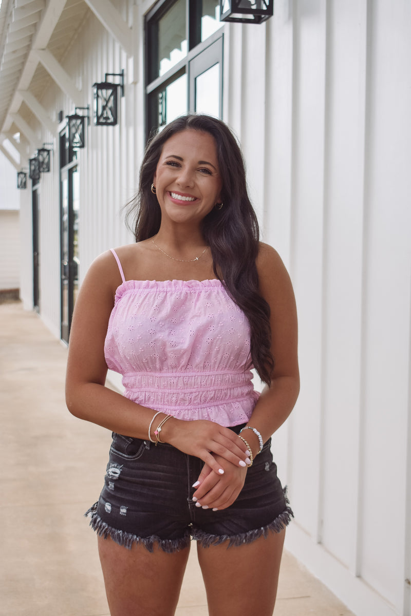 eyelet top in pink, featuring an elastic waist with ruffles and adjustable spaghetti straps!