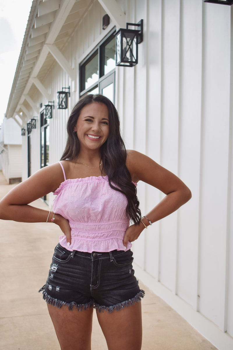 eyelet top in pink, featuring an elastic waist with ruffles and adjustable spaghetti straps!