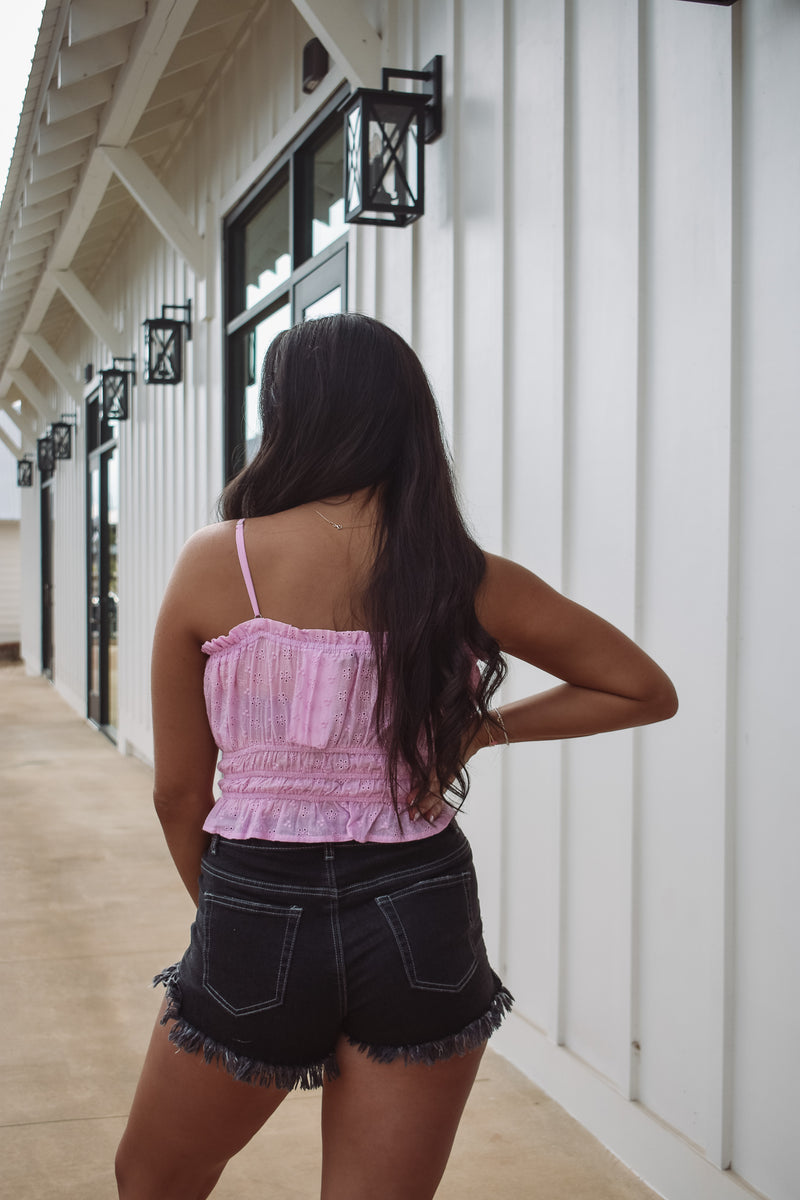 eyelet top in pink, featuring an elastic waist with ruffles and adjustable spaghetti straps!