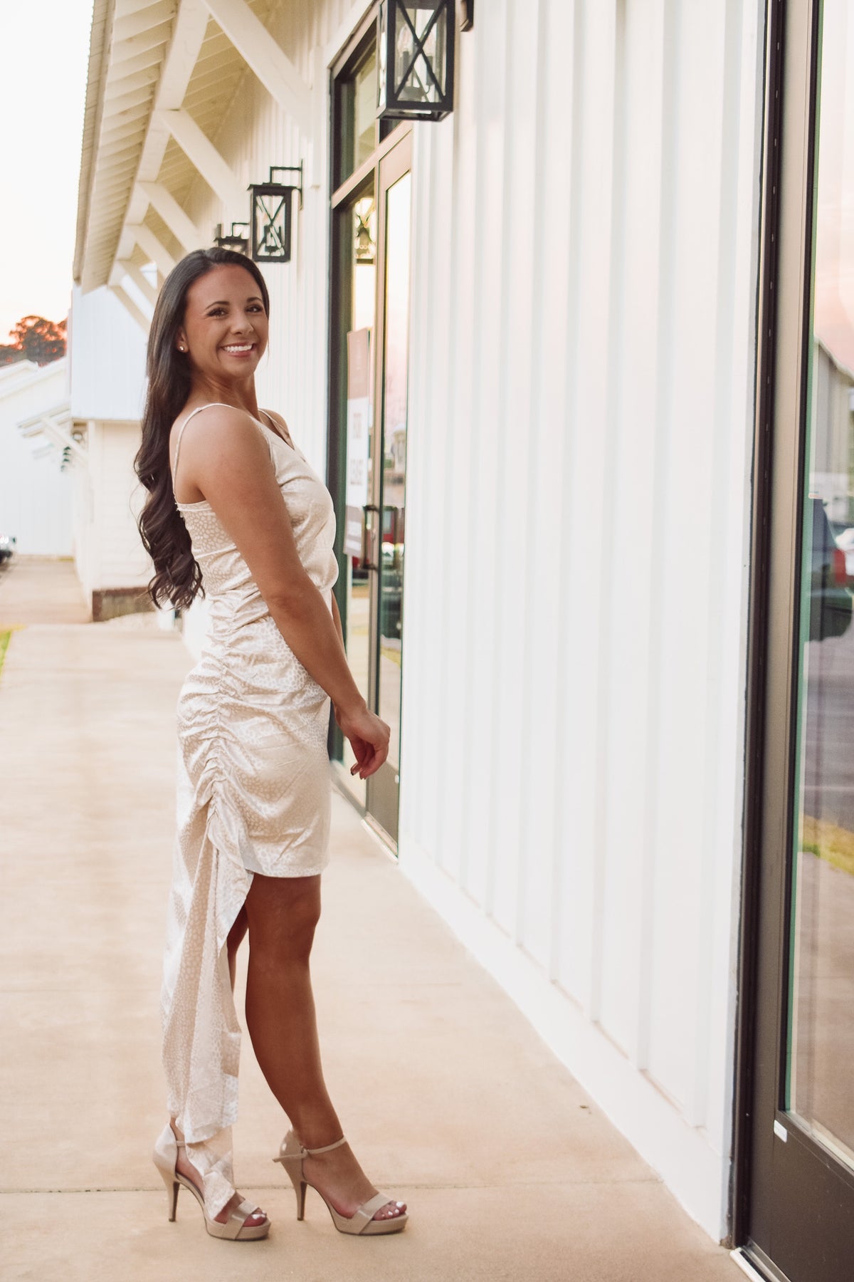 Gorgeous cream color asymmetric satin mini dress featuring adjustable spaghetti straps, cowl neckline, side slit along bottom hem, and back zipper closure!