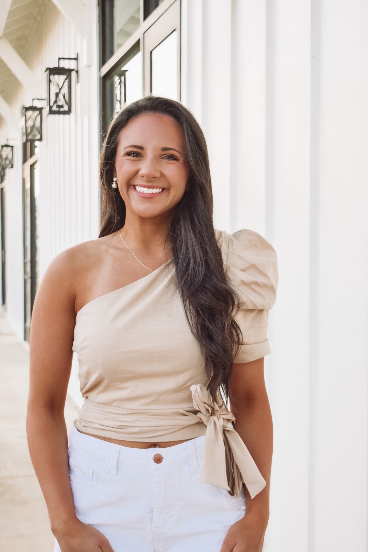 We are in love with this pretty top in a neutral color, featuring cropped fit, smocked back hem, side zipper, one shoulder with puff sleeve and a front tie

